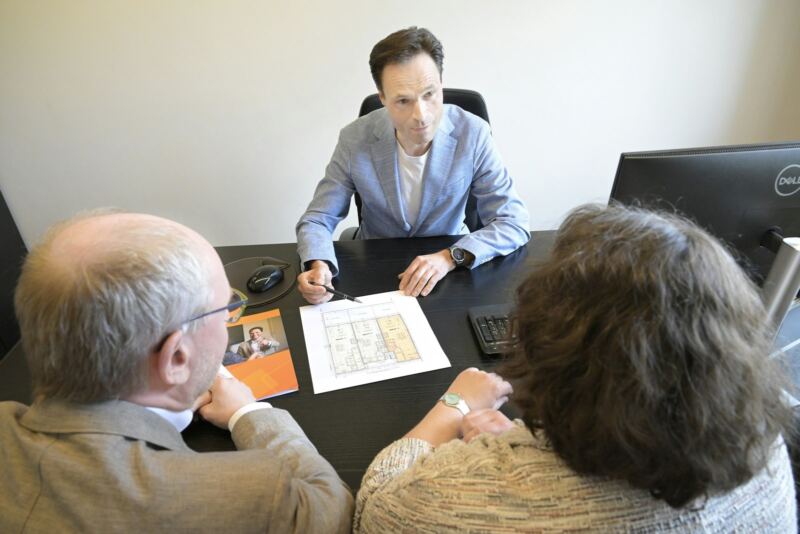 A consultant explaining a plan to a couple across a desk