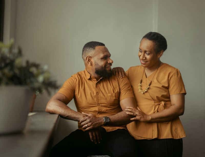A couple talking closely on their couch at home